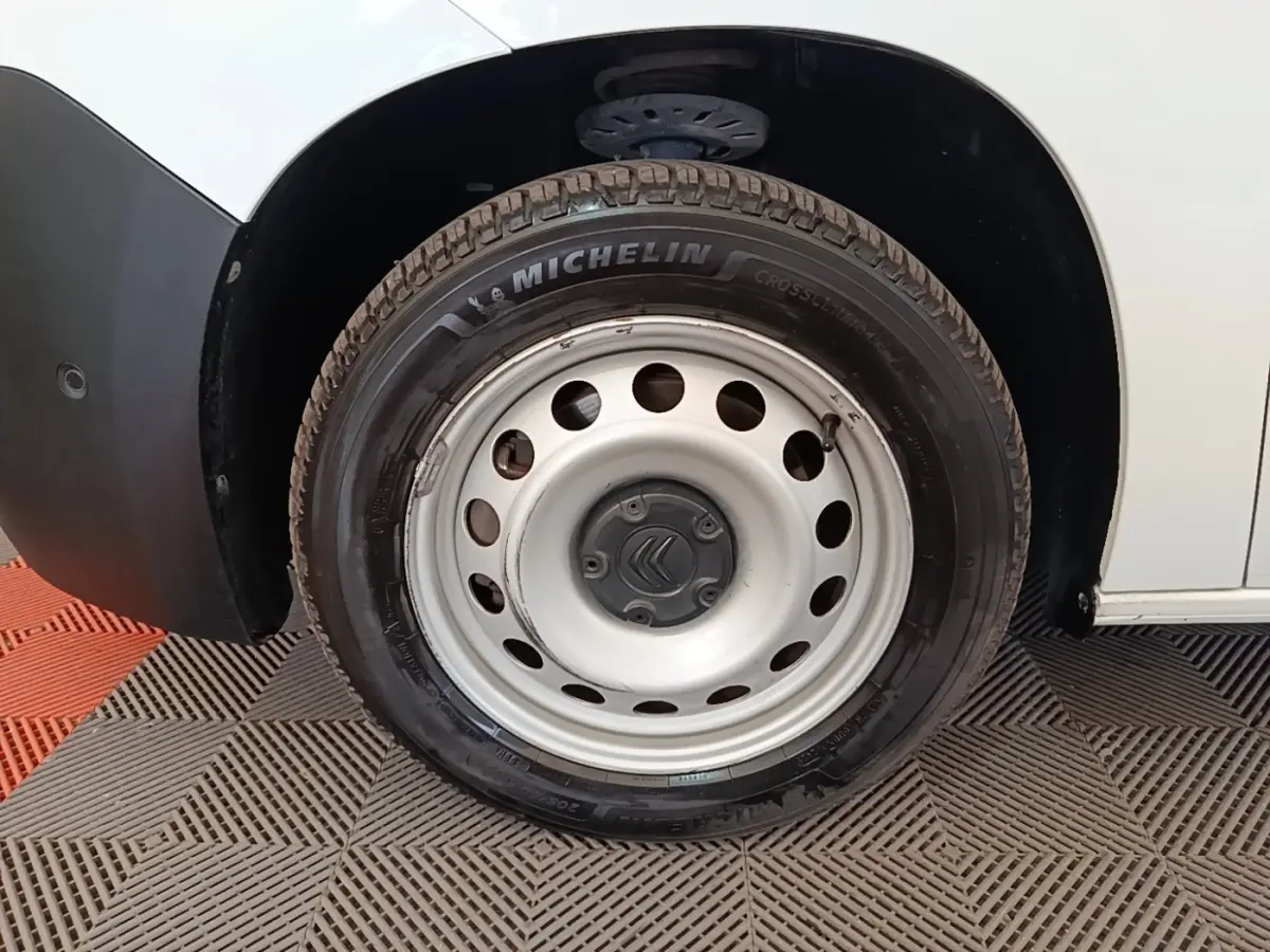 Gros plan sur la roue avant gauche blanche d’un Citroën Berlingo 2020 avec jante acier et pneu Michelin.