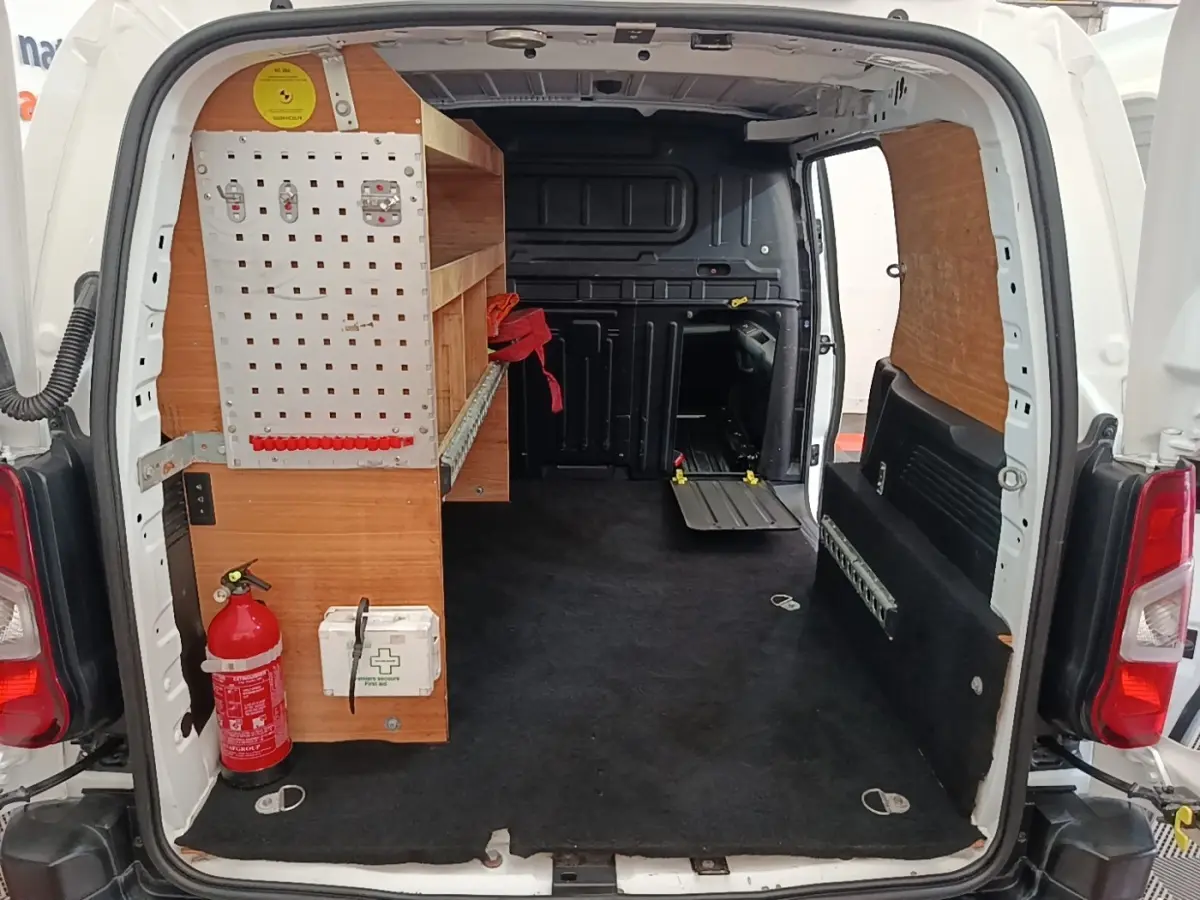 Vue arrière ouverte du Citroën Berlingo blanc avec aménagement bois et extincteur visible dans l’espace de chargement.
