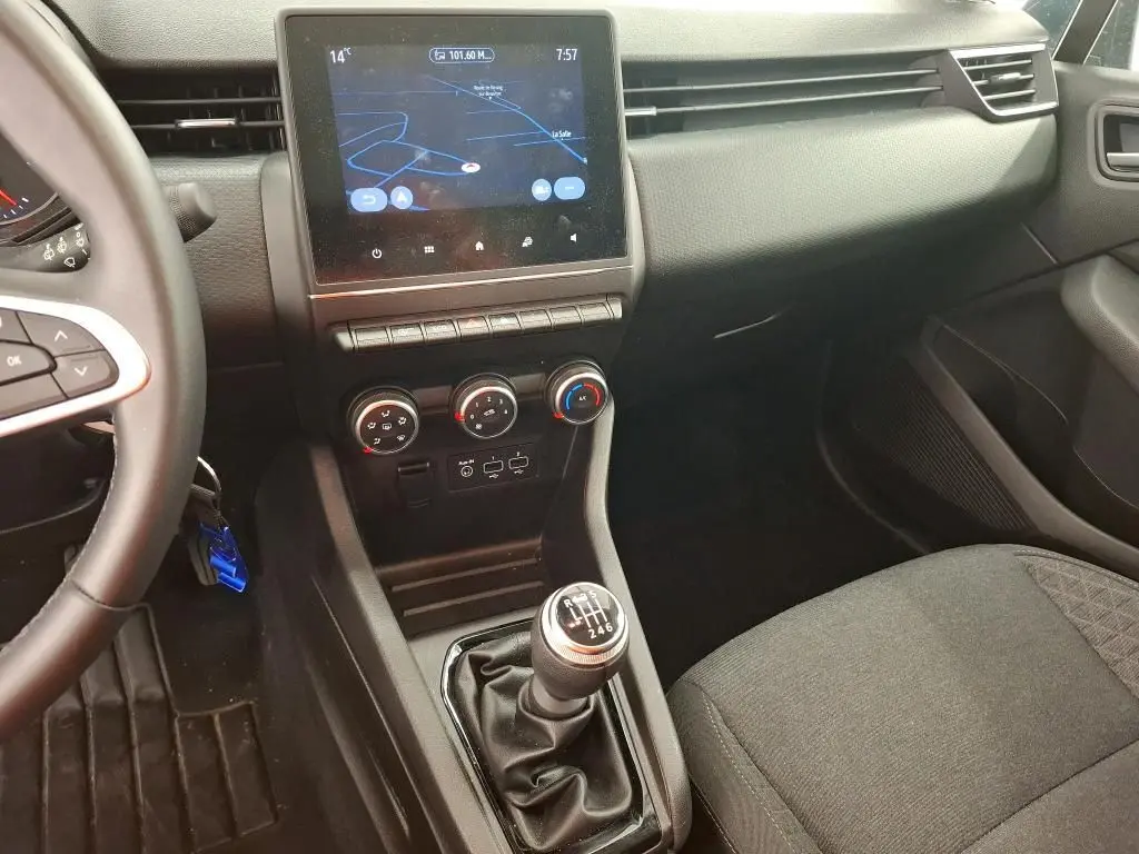 Vue intérieure de la Renault Clio Business Edition 2022, montrant la console centrale avec écran tactile et levier de vitesses manuel.