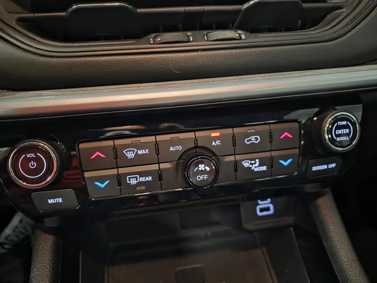 Panneau de commande de climatisation et audio du Jeep Compass 2022 noir, avec boutons rétroéclairés et molette centrale.