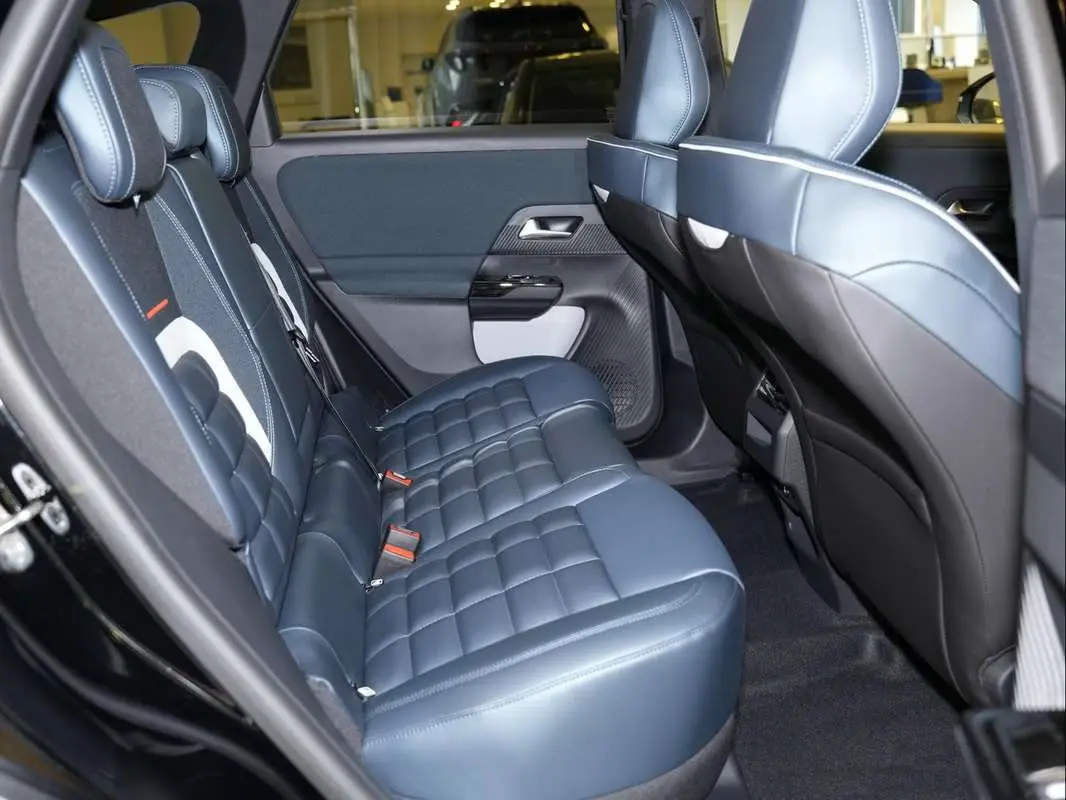 Vue intérieure côté gauche montrant la banquette arrière en cuir bleu matelassé du Citroën C5 Aircross New Hybrid 2026.