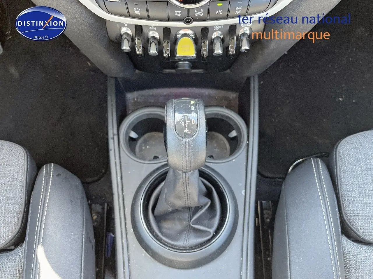 Gros plan sur la console centrale de la MINI Countryman hybride avec levier de boîte auto et porte-gobelets.