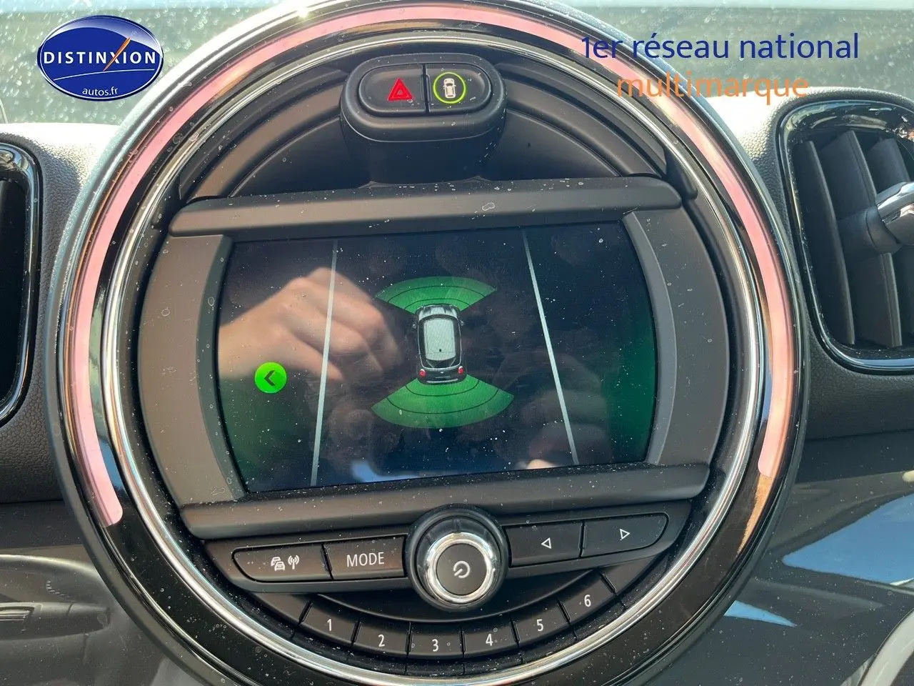Affichage du système de stationnement assisté sur l'écran central rond du MINI Countryman Cooper SE gris Moonwalk, vue intérieure.