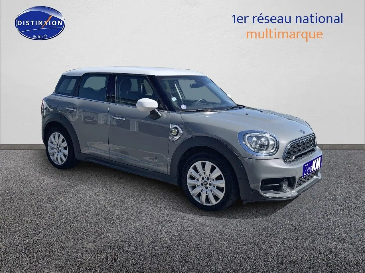 Vue 3/4 avant droit d'une MINI Countryman hybride Moonwalk Grey avec toit et rétroviseurs blancs.