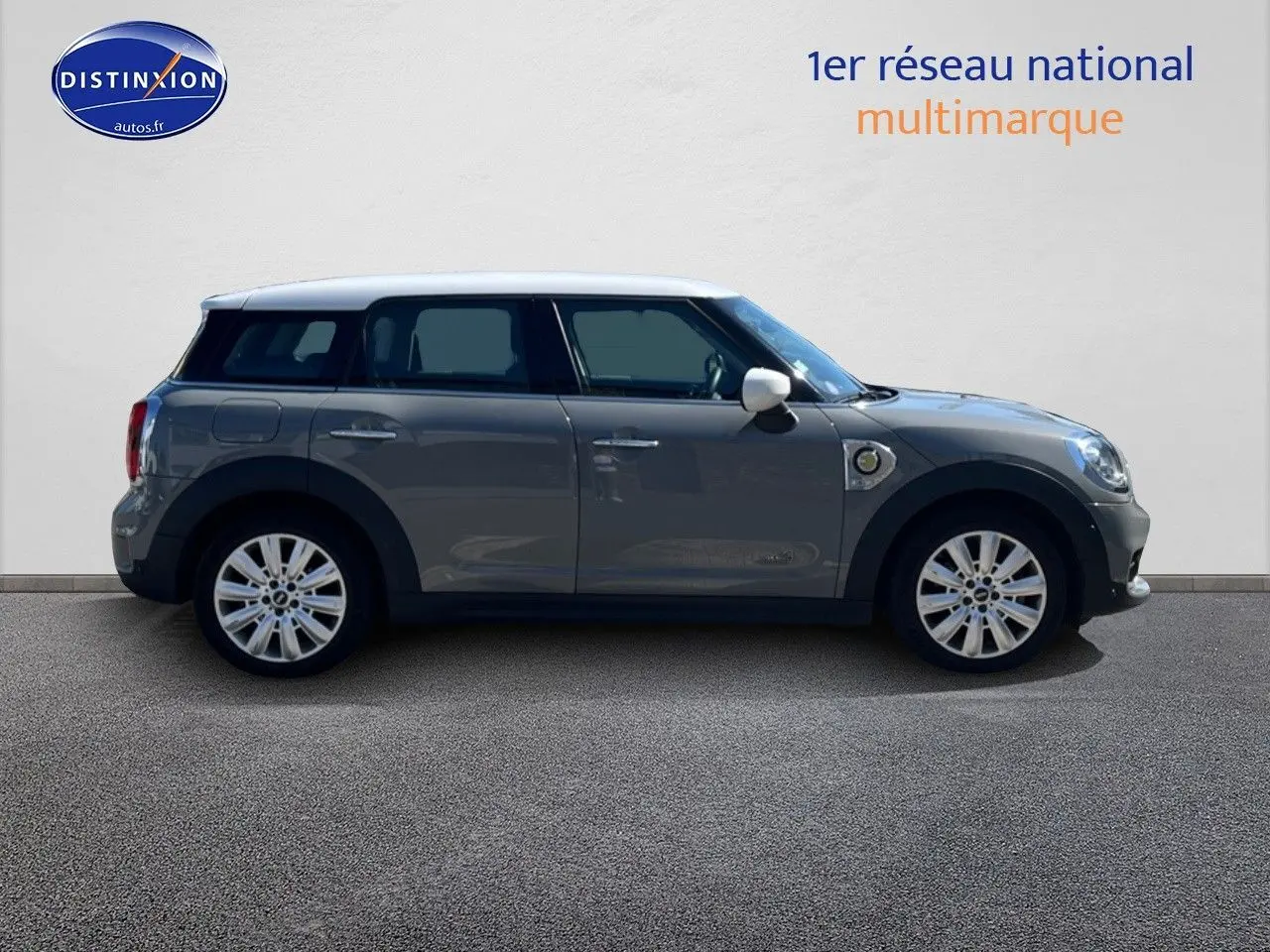 Profil droit d'une MINI Countryman Cooper SE Moonwalk Grey avec toit et rétroviseurs blancs, jantes 18 pouces design Pin Spoke.