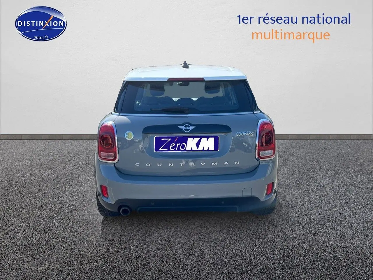 Vue arrière d'une MINI Countryman Cooper SE Moonwalk Grey avec toit blanc et feux LED, sur fond neutre.