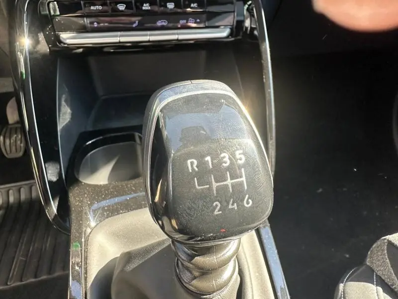 Gros plan sur le levier de vitesses manuel noir du Citroën C3 1.2 Turbo 100ch MAX 2025, avec console centrale brillante.