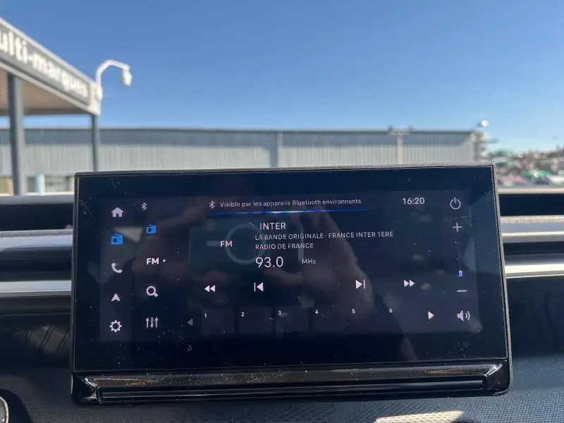 Écran tactile central de la Citroën C3 2025 affichant la radio FM sur fond de tableau de bord noir.