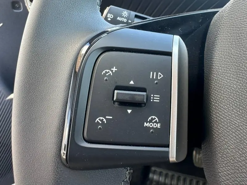 Gros plan sur les commandes au volant noir de la Citroën C3 1.2 Turbo 100ch MAX 2025, boutons de régulateur de vitesse visibles.