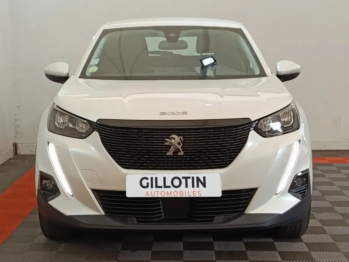 Peugeot 2008 blanc vue de face, avec calandre noire et feux LED diurnes verticaux allumés.