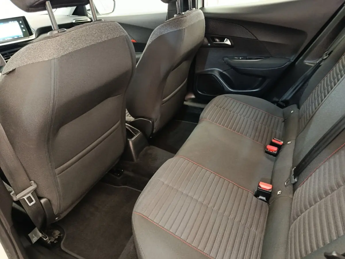 Vue intérieure arrière droite de la banquette tissu gris foncé avec surpiqûres rouges du Peugeot 2008 blanc de 2021.