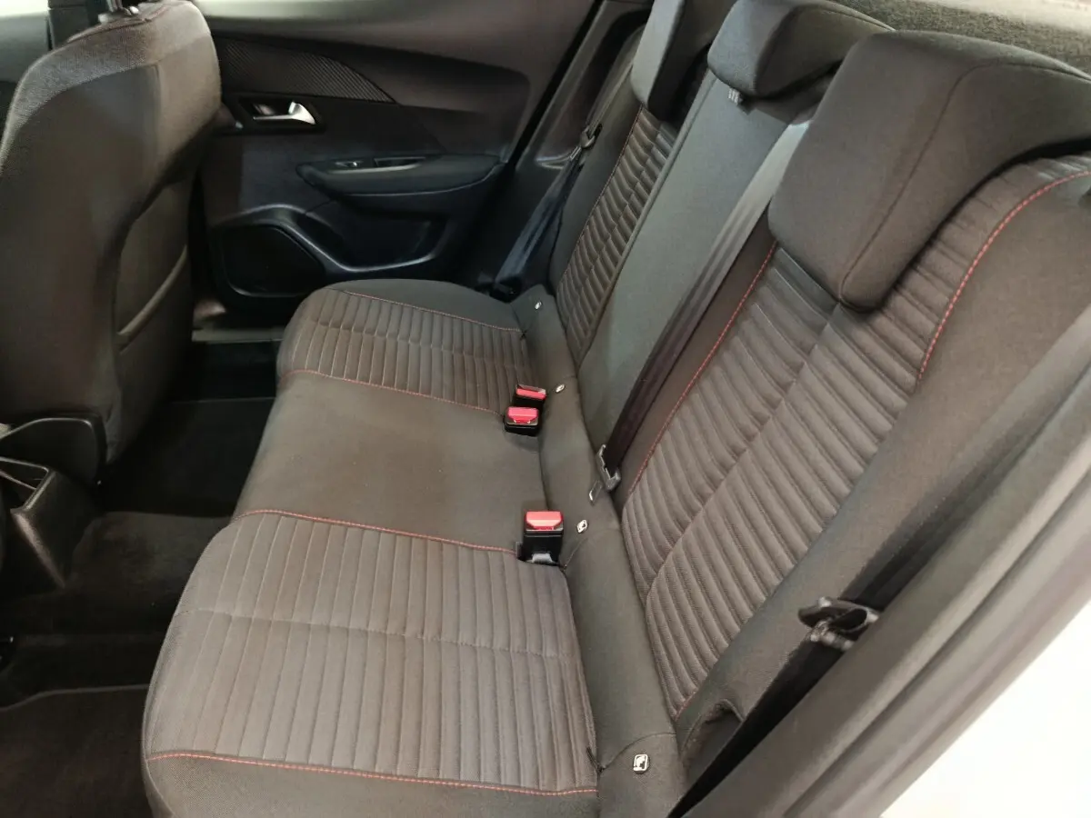 Vue intérieure côté droit sur la banquette arrière grise avec surpiqûres rouges du Peugeot 2008 blanc.