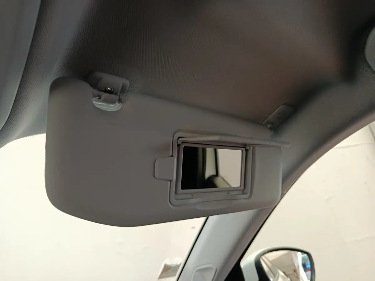 Miroir de courtoisie ouvert sur pare-soleil côté conducteur dans l’habitacle blanc du Peugeot 2008 2021.