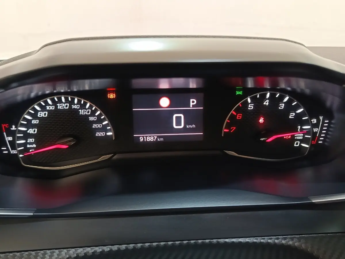 Vue rapprochée du tableau de bord numérique de la Peugeot 2008, affichant la vitesse à 0 km/h et le compteur kilométrique.