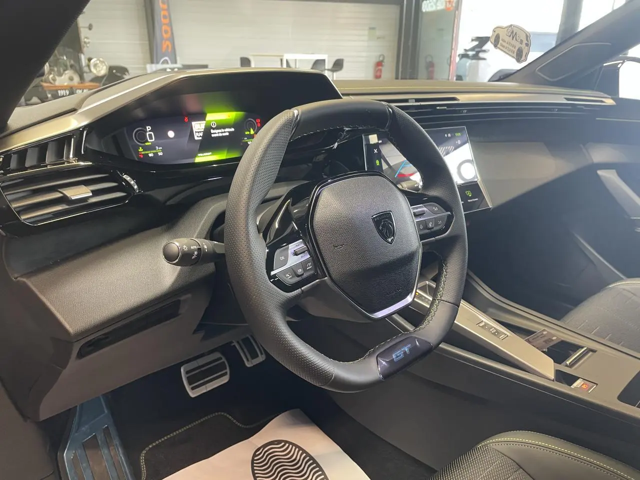 Vue intérieure côté conducteur du Peugeot 308 GT 2026, avec volant cuir GT et tableau de bord numérique moderne.
