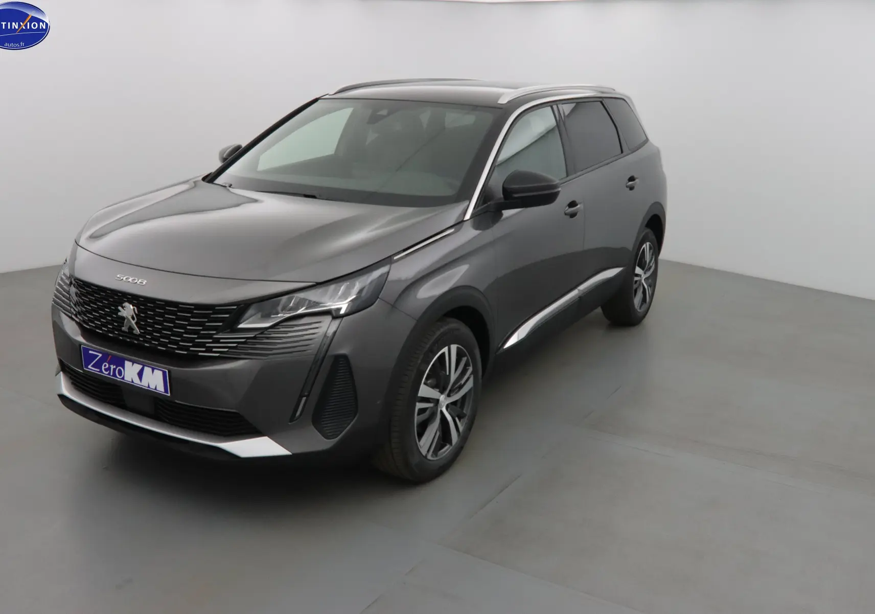 Peugeot 5008 gris platinium métal en vue 3/4 avant droit, avec calandre noire et jantes alliage bicolores.