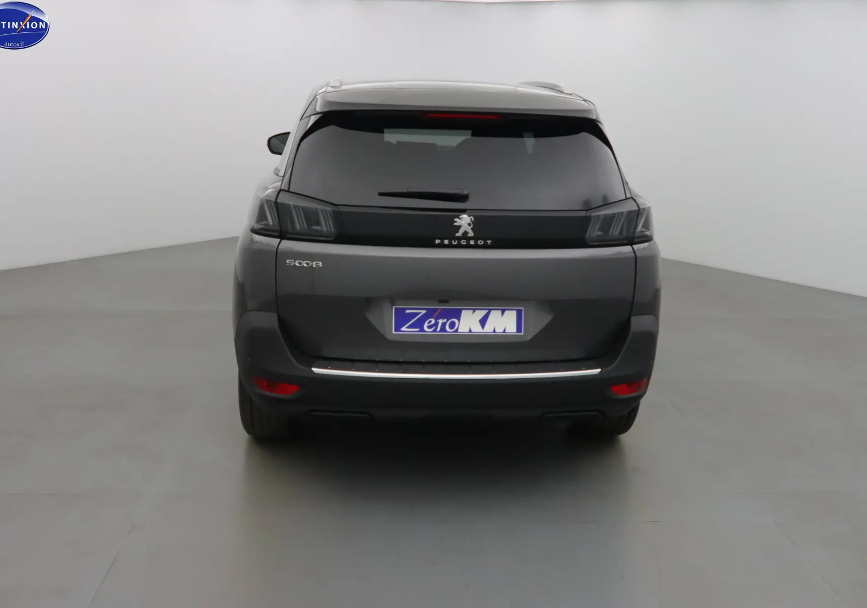 Vue arrière d'un Peugeot 5008 gris platinium métal avec feux LED et hayon fermé dans un studio blanc.