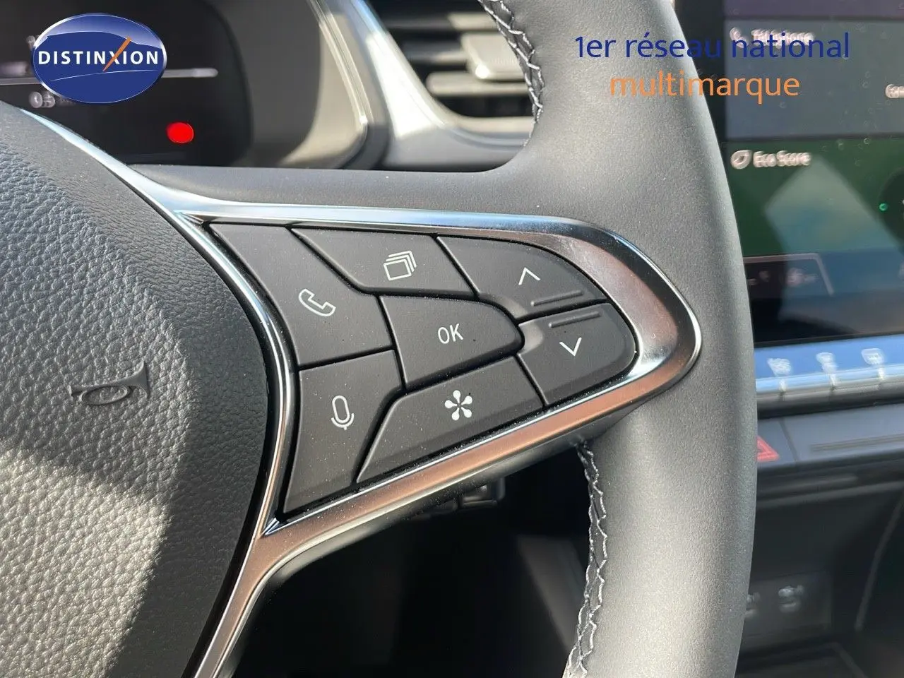 Gros plan sur les commandes multifonctions à droite du volant du Renault Captur noir étoile métal avec toit gris, intérieur moderne.
