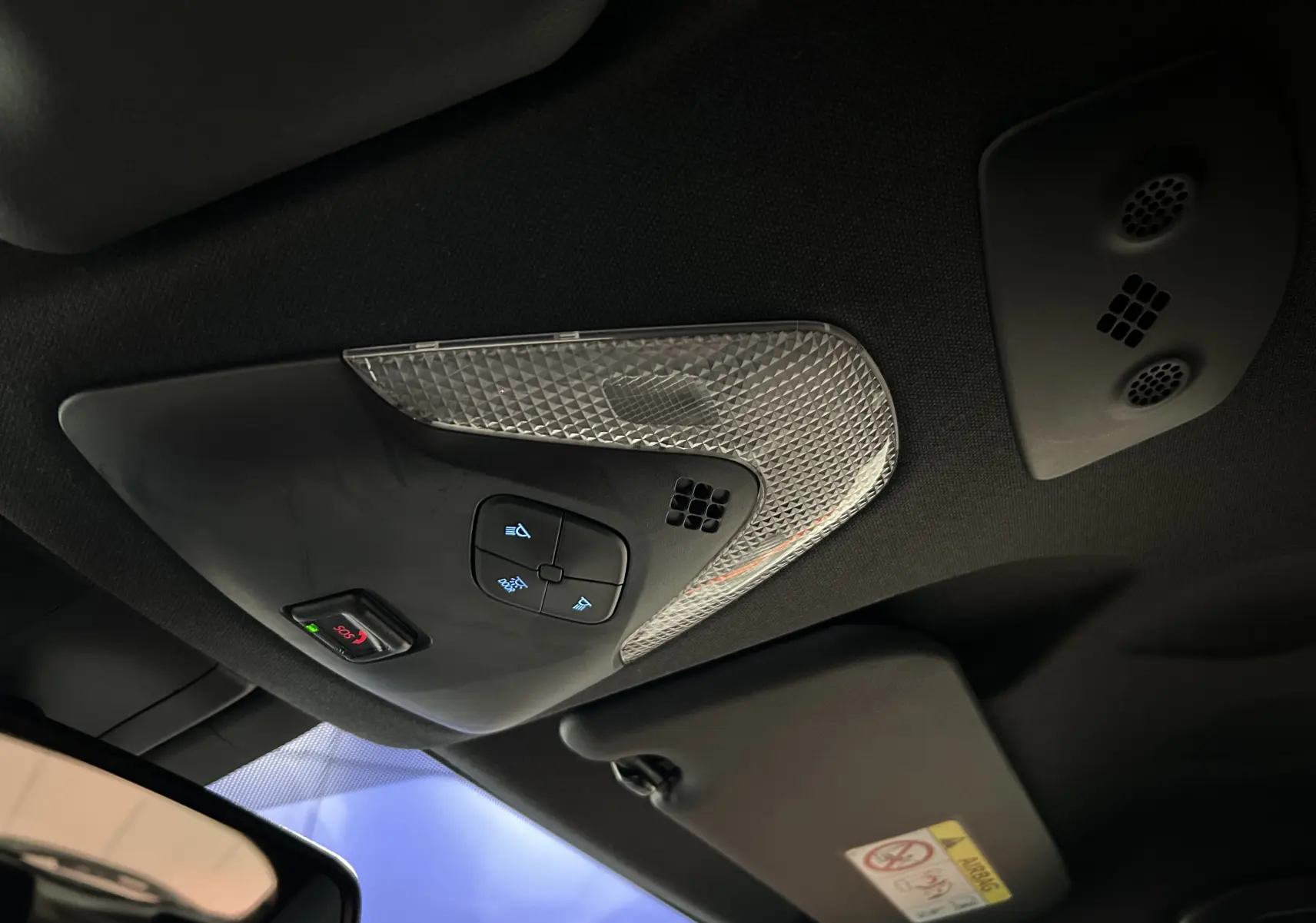 Plafonnier intérieur avec commandes d’éclairage et bouton SOS, vue du toit d’un Toyota C-HR Hybride noir métal 2021.