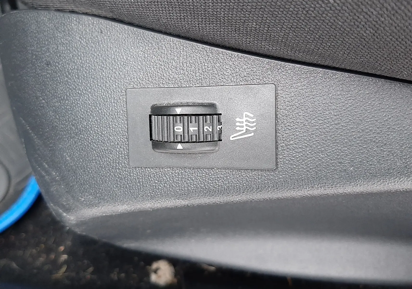 Réglage du chauffage de siège en gros plan sur la console intérieure noire d'une Peugeot 208 Bleu Nuit 2019