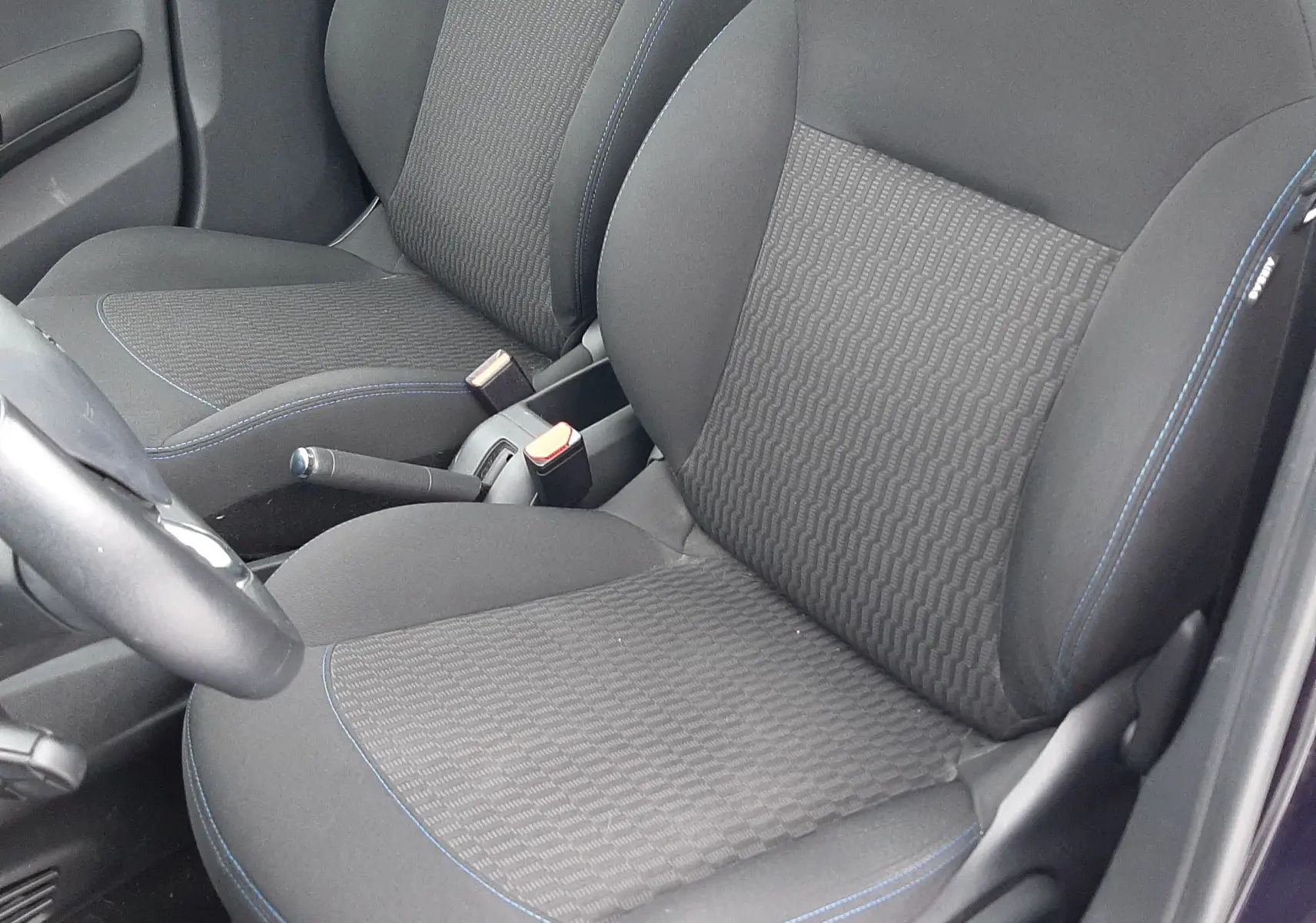 Vue rapprochée des sièges avant en tissu noir avec surpiqûres bleues du Peugeot 208 Bleu Nuit 2019.