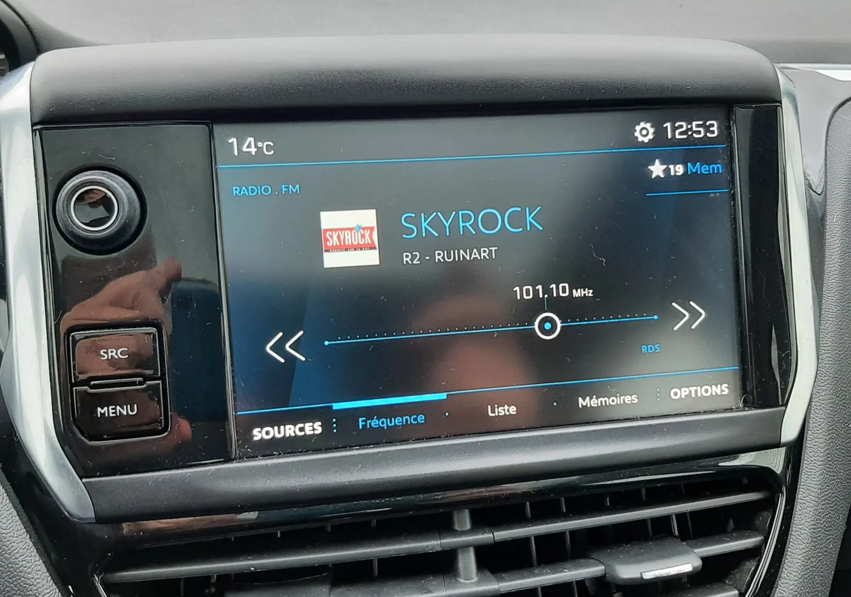 Écran tactile central du tableau de bord de la Peugeot 208 bleu nuit, affichant la radio Skyrock à 101,10 MHz.