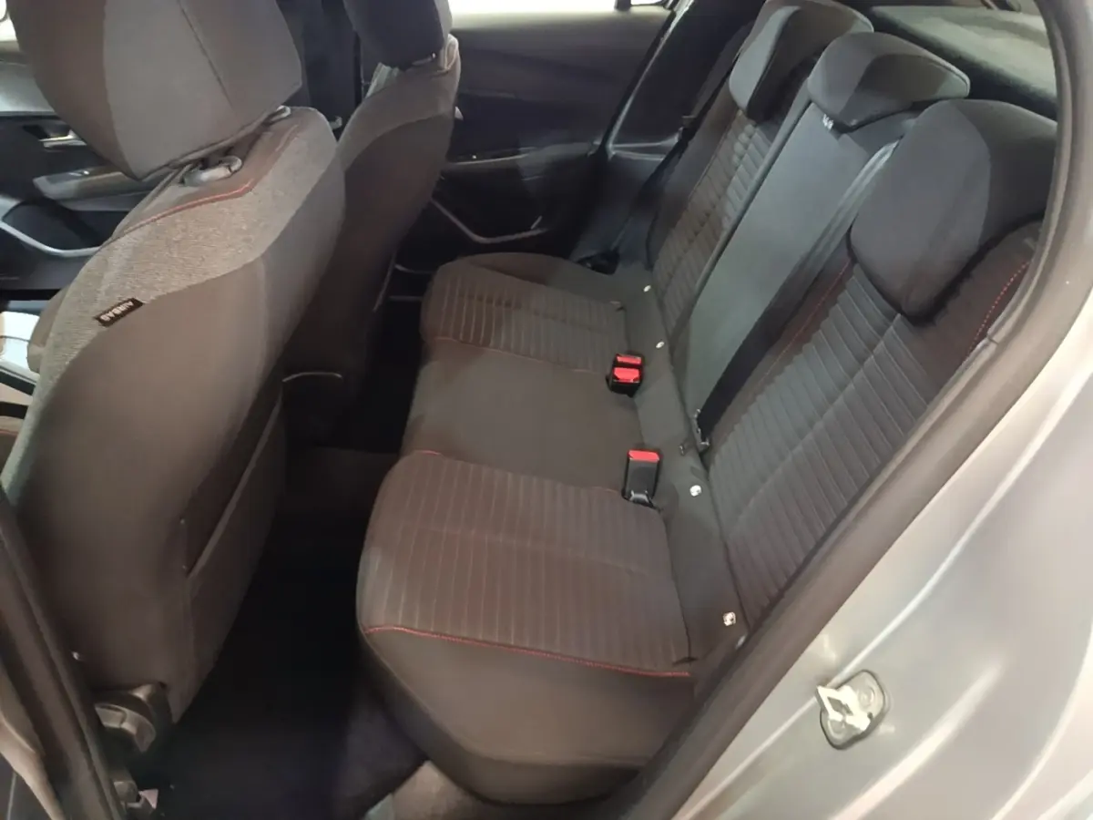 Vue intérieure côté droit sur la banquette arrière noire avec surpiqûres rouges d'une Peugeot 208 gris clair 2023.