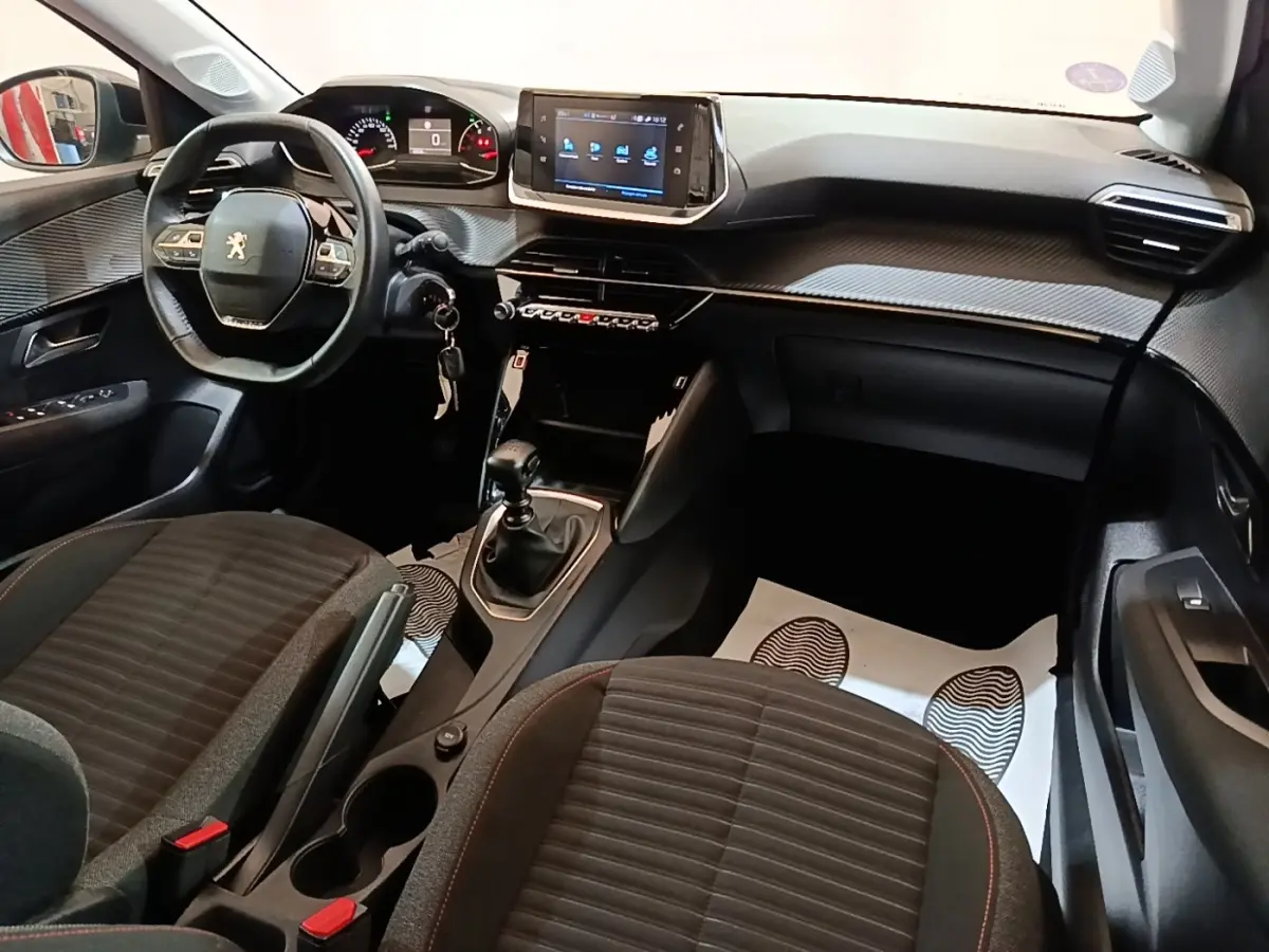 Intérieur de la Peugeot 208 gris clair, vue côté conducteur, volant cuir multifonctions et écran tactile central.