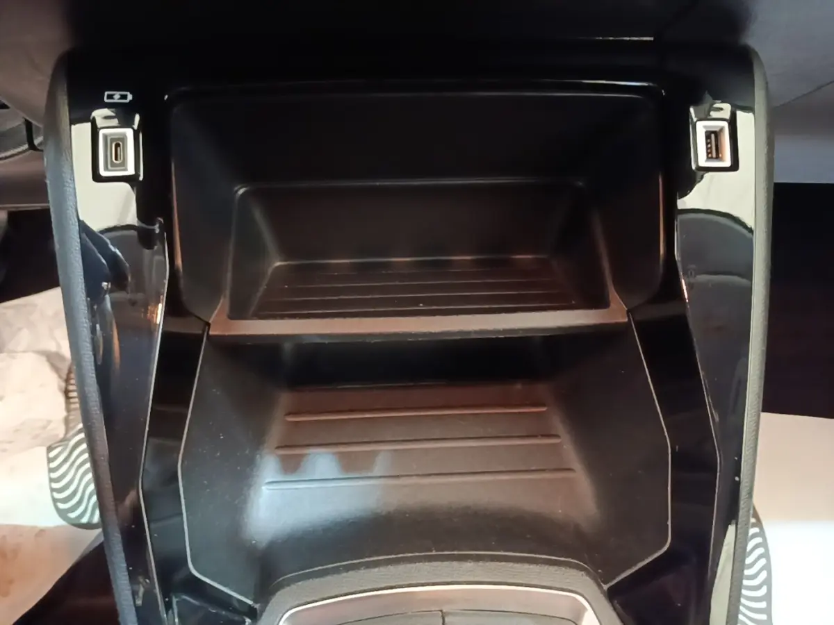 Vue rapprochée de la console centrale noire de la Peugeot 208 PureTech 100 S&S Active Pack avec ports USB visibles.