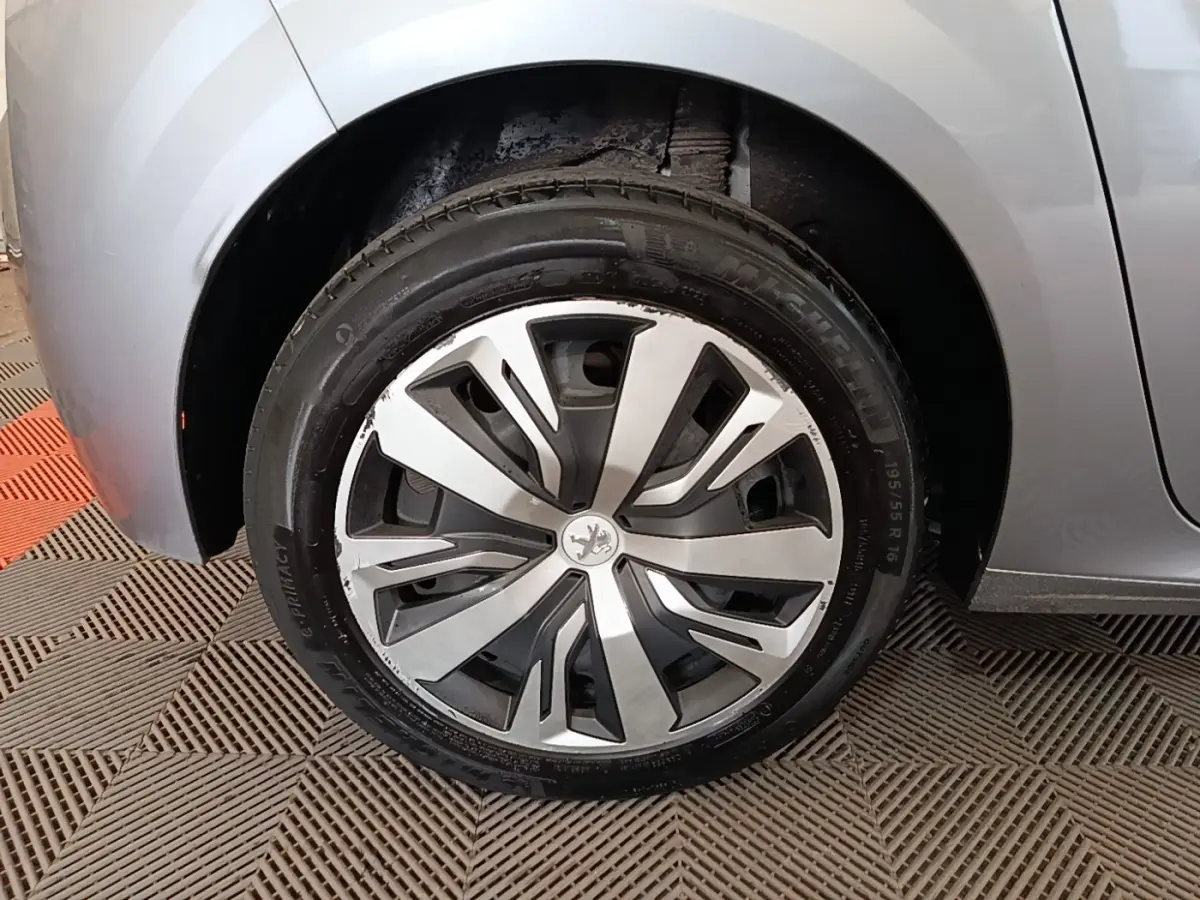 Gros plan sur la roue avant gauche gris clair d'une Peugeot 208 PureTech 100 S&S Active Pack 2023 avec jante stylisée.