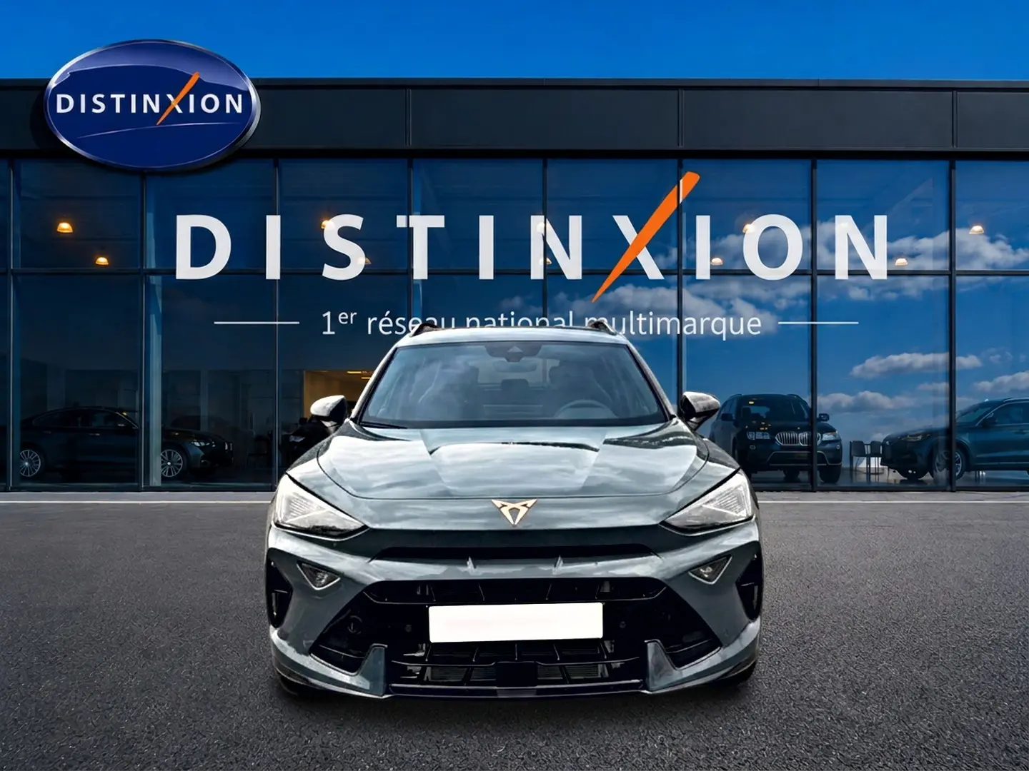 Vue frontale d'un CUPRA Formentor bleu fjord 2026 avec calandre marquée et logo CUPRA distinctif sur fond de vitrine Distinxion.