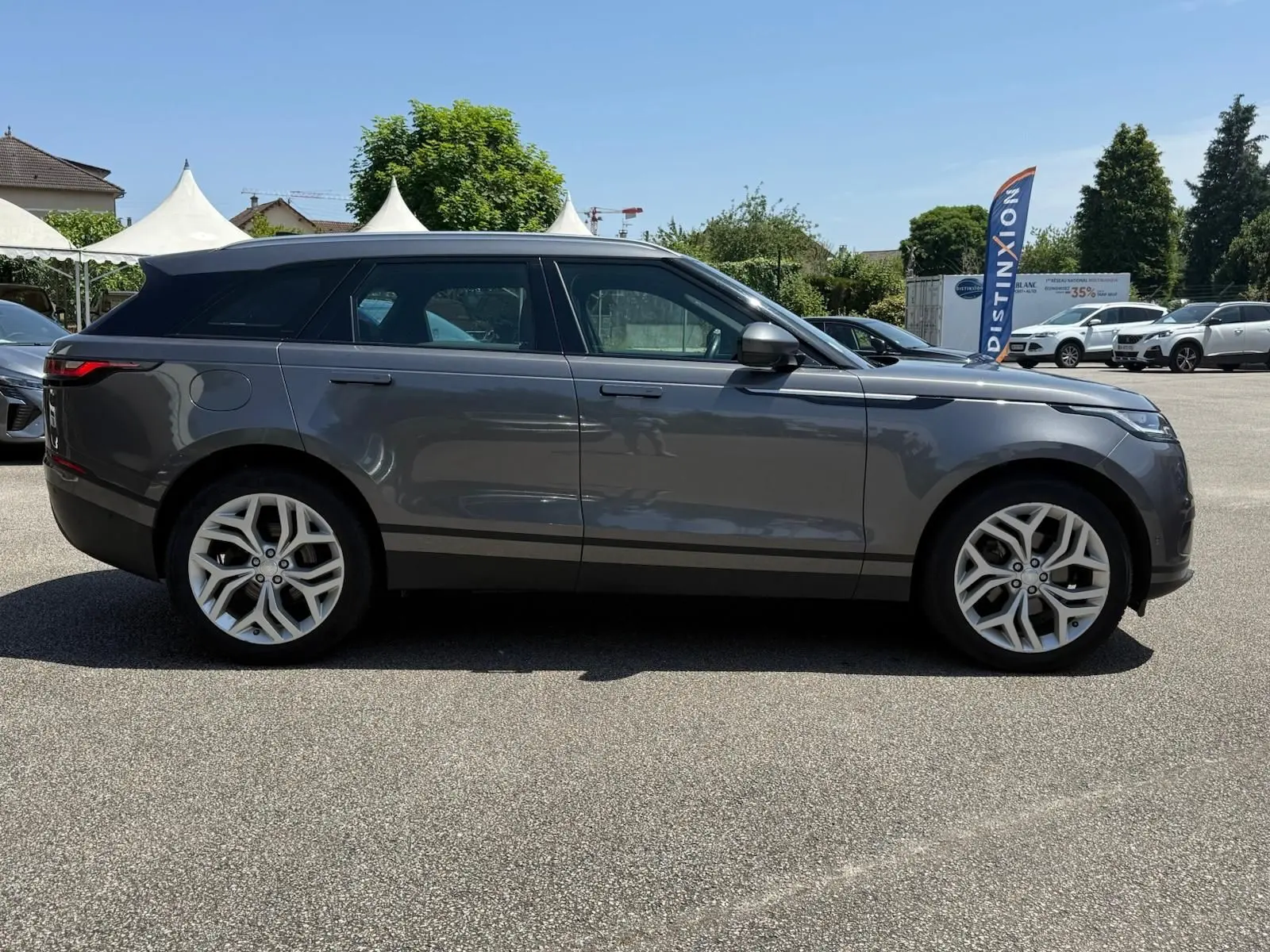 Profil latéral droit d'un Range Rover Velar gris 2019, soulignant ses jantes alliage et lignes épurées.