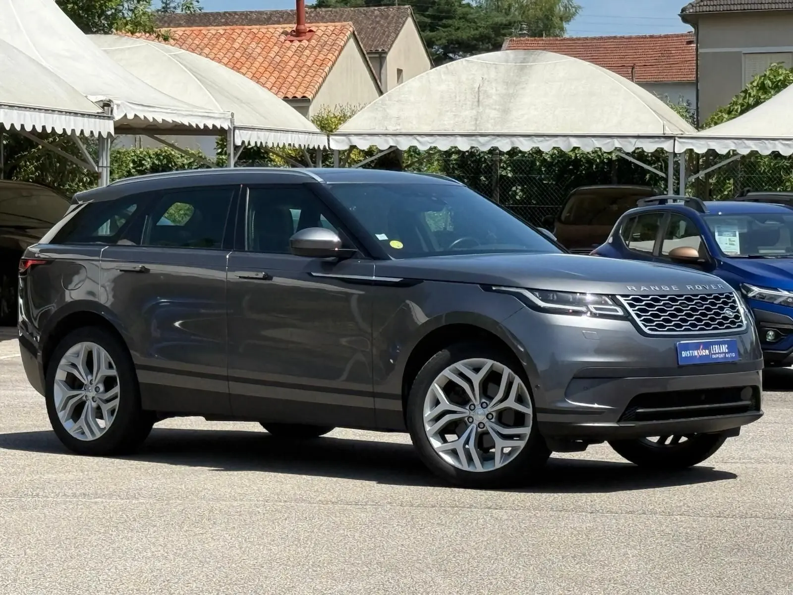 Range Rover Velar gris en vue profil côté gauche, soulignant ses jantes alliage et sa silhouette élégante.