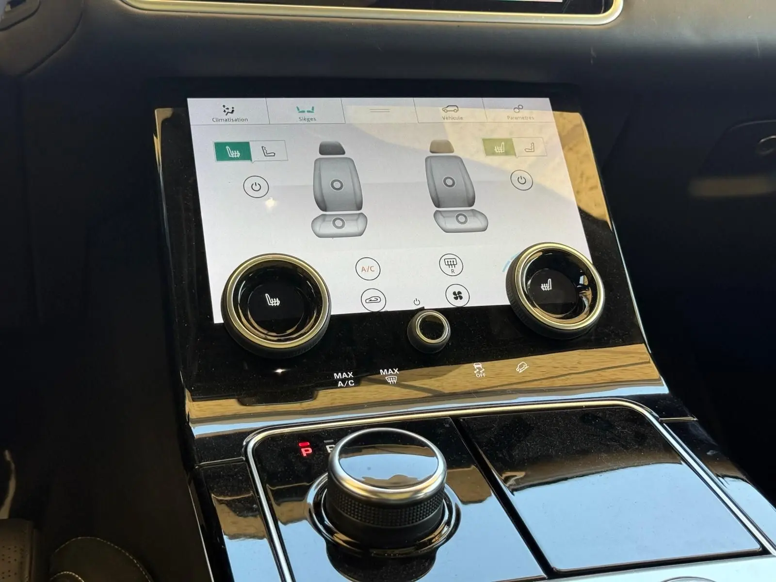 Gros plan sur la console centrale du Range Rover Velar 2019, écran tactile et commandes de climatisation visibles.