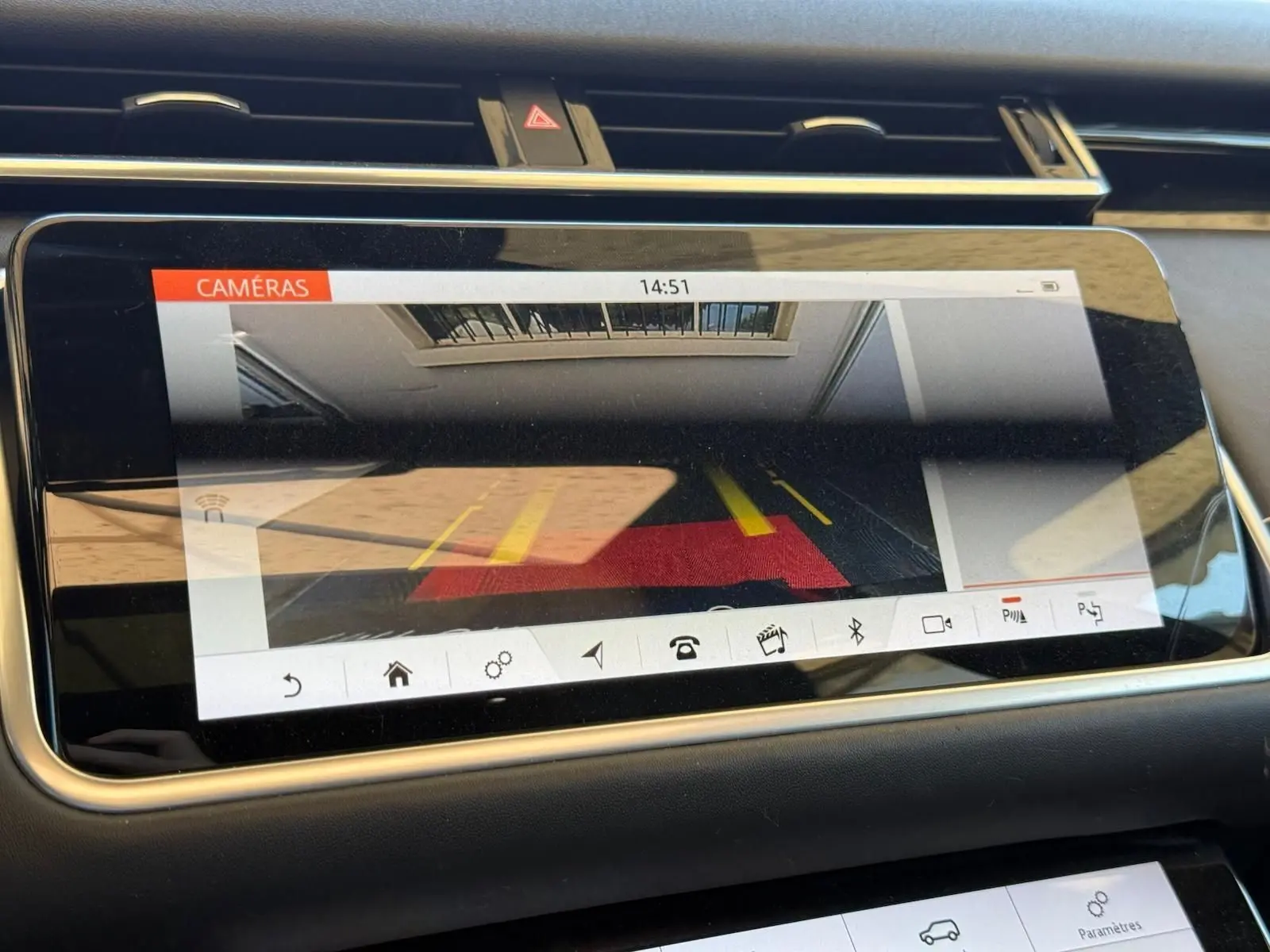 Écran tactile intérieur du Range Rover Velar 2019 montrant la caméra de recul avec guidage de trajectoire.