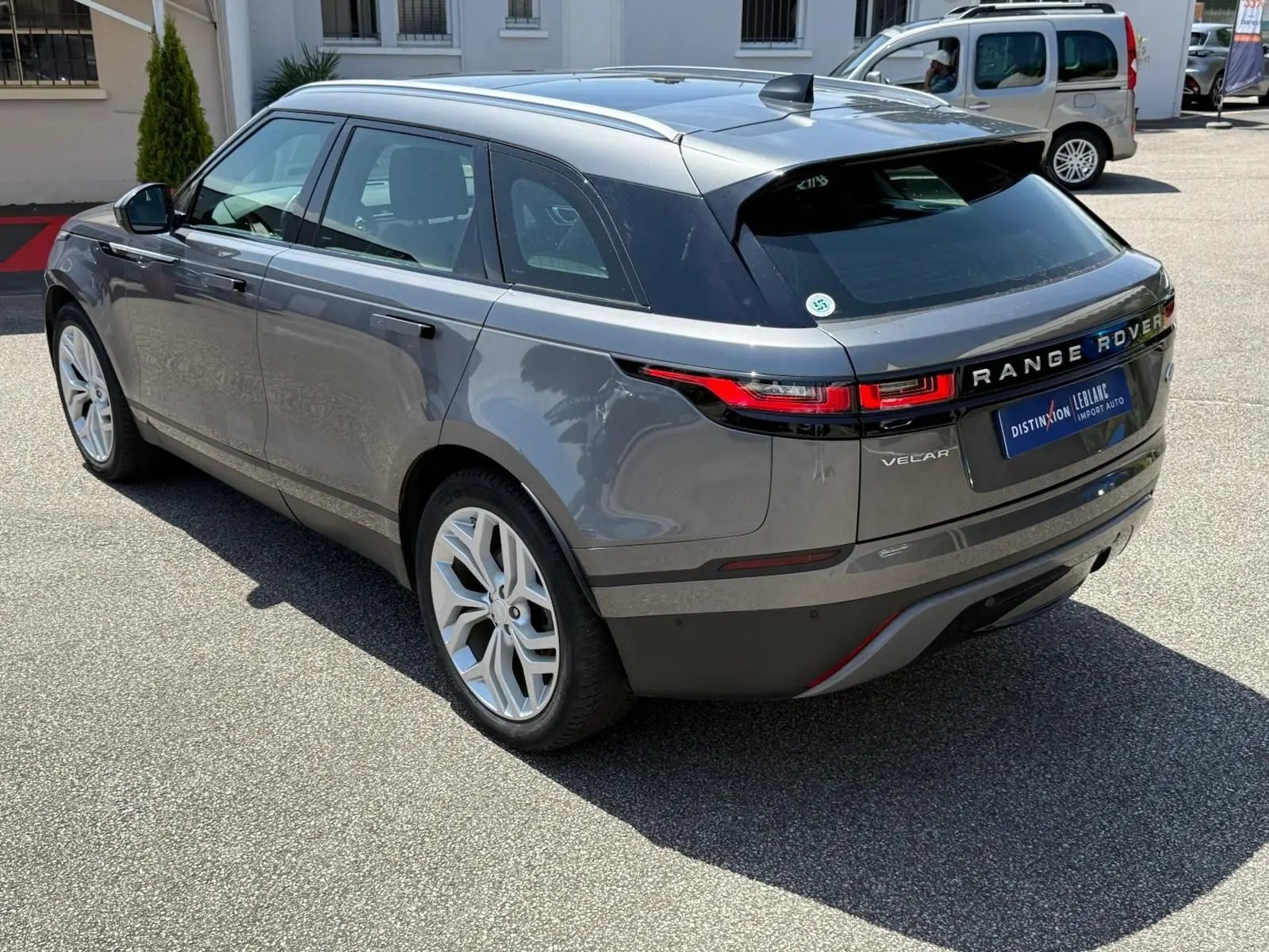 Vue 3/4 arrière droite d'un Range Rover Velar gris métallisé, soulignant ses feux arrière LED et ses jantes alliage.