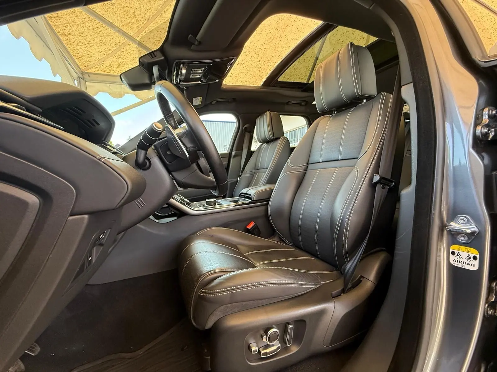 Intérieur du Range Rover Velar gris 2019, vue côté conducteur sur sièges cuir Windsor et tableau de bord moderne.