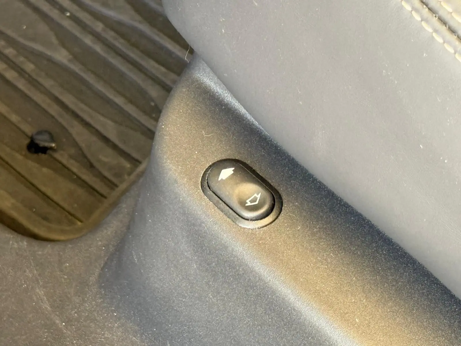 Gros plan sur le bouton de réglage du siège côté droit, sur le revêtement cuir gris du Range Rover Velar 2019.