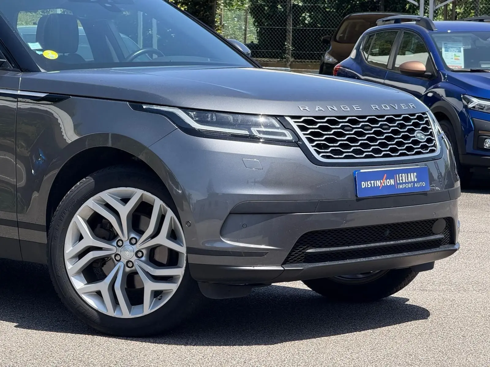 Vue 3/4 avant d'un Range Rover Velar gris métallisé mettant en valeur sa calandre distinctive et ses jantes alliage.