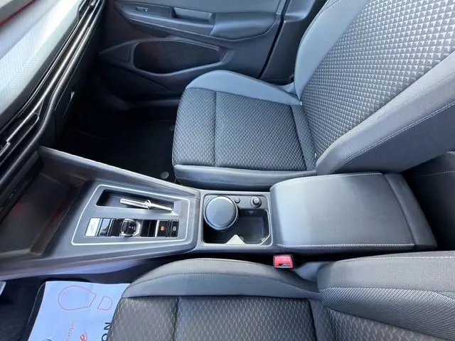 Vue intérieure centrée sur la console centrale et sièges avant gris foncé de la Volkswagen Golf VIII 2.0 TDI.