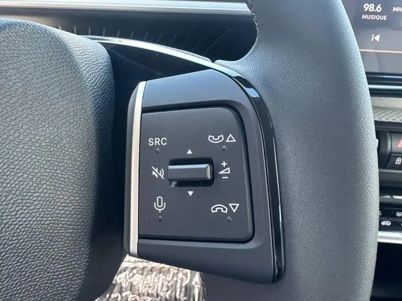 Gros plan sur les commandes multifonctions au volant côté gauche du Citroën C3 Aircross gris Mercury.