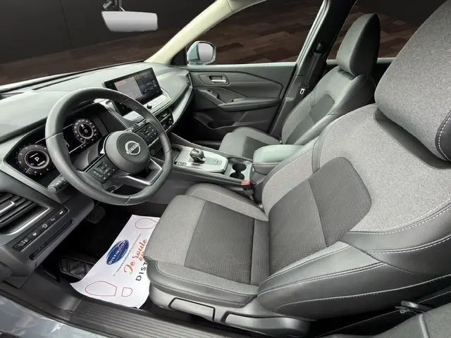 Vue intérieure côté conducteur du Nissan Qashqai 2025 gris foncé, avec tableau de bord numérique et écran tactile central.
