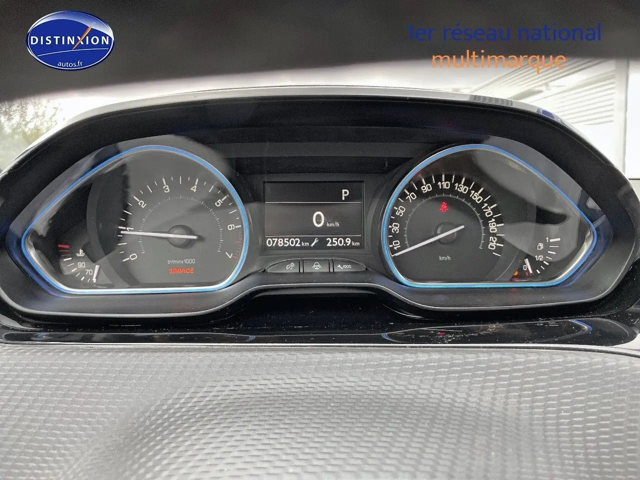 Tableau de bord du Peugeot 2008 essence blanc nacré, affichant compteur et vitesse à l'arrêt.