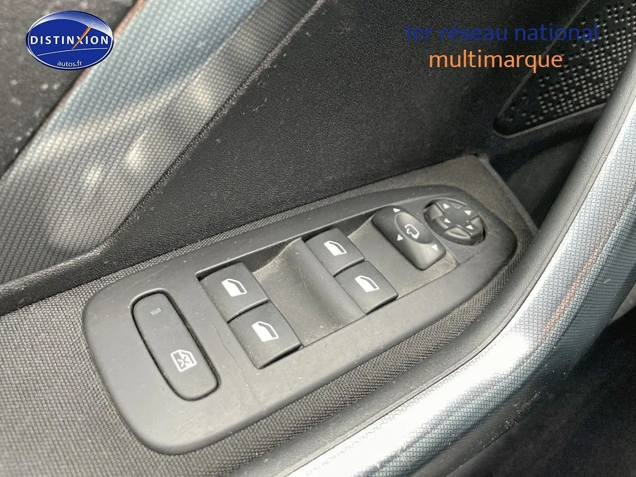 Gros plan sur les commandes des vitres électriques côté conducteur d'un Peugeot 2008 blanc nacré, finition Allure.