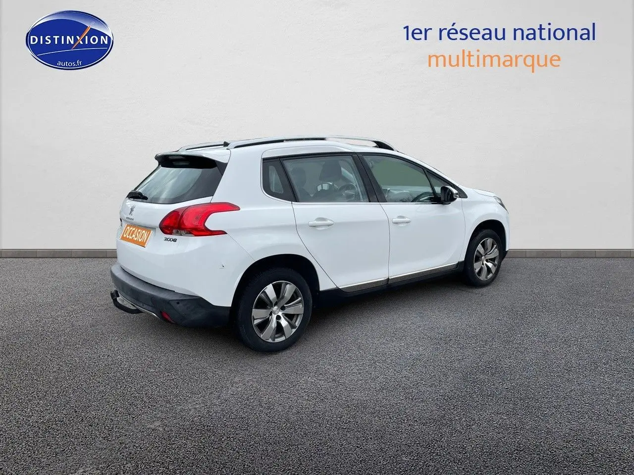 Peugeot 2008 blanc nacré en 3/4 arrière droit, SUV compact avec jantes alliage et barres de toit noires.