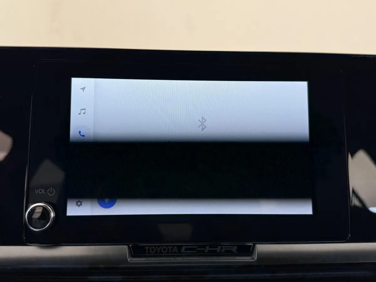 Écran tactile central allumé avec interface Bluetooth sur tableau de bord noir du Toyota C-HR blanc 2024.