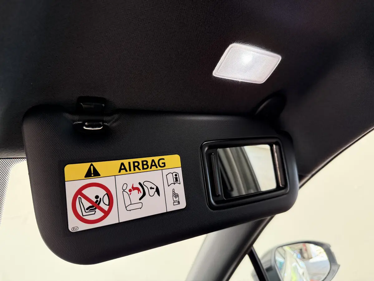 Détail du pare-soleil côté conducteur avec miroir et avertissement airbag dans un Toyota C-HR blanc 2024.
