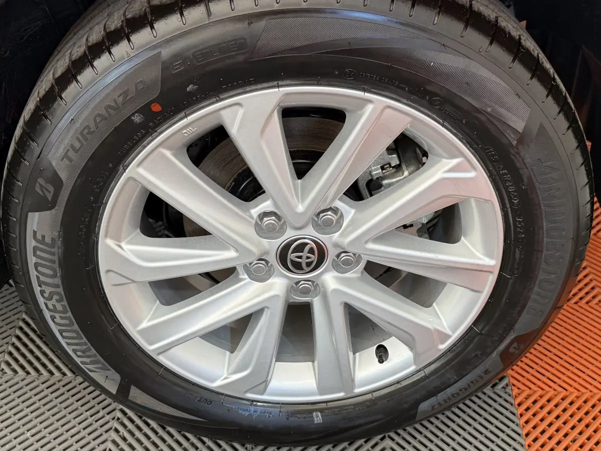 Gros plan sur la jante argentée et le pneu Bridgestone du Toyota C-HR blanc 2024 hybride.