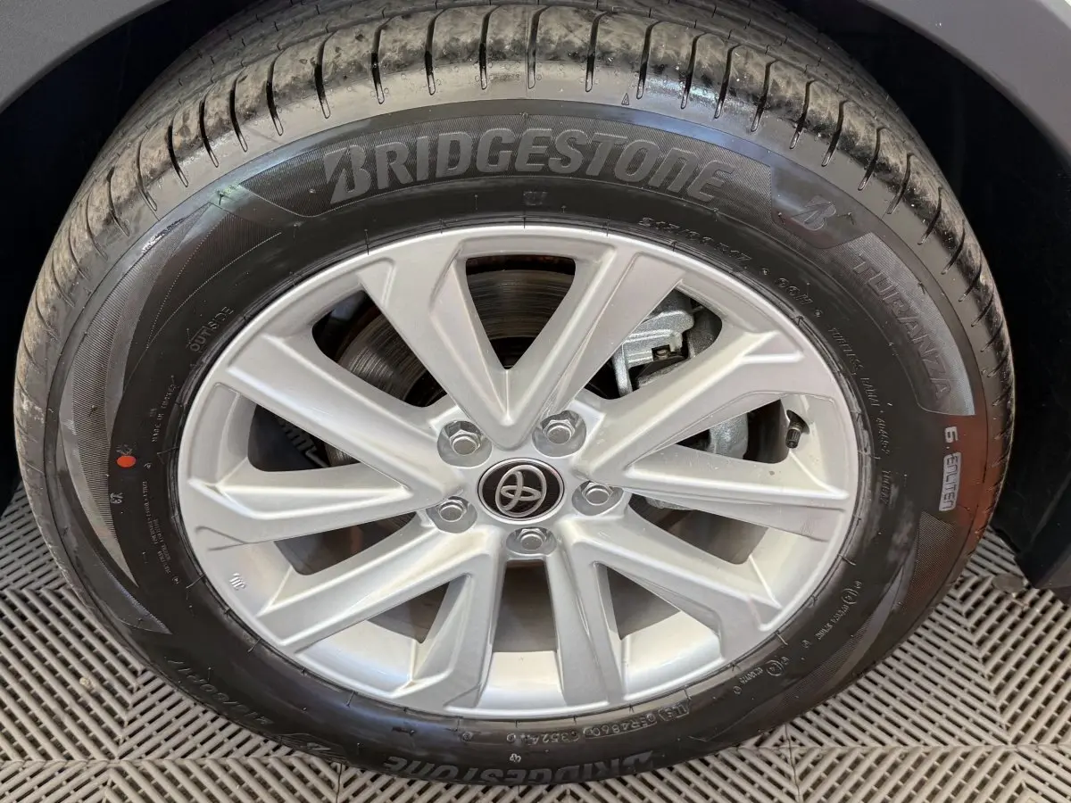 Gros plan sur la jante alliage argentée et pneu Bridgestone du Toyota C-HR 1.8 Hybride blanc, côté droit.