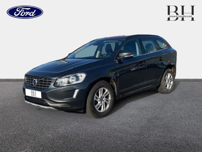 Vue 3/4 avant droit d'un Volvo XC60 gris Savile 2016, avec jantes alu et calandre distinctive Volvo.
